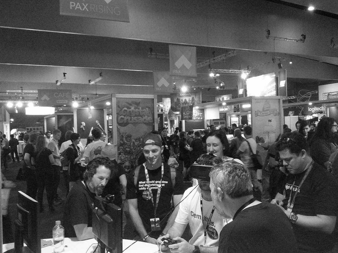 A crowd watches a player in an Oculus Rift headset at the Eyemobi stand at PAX Rising